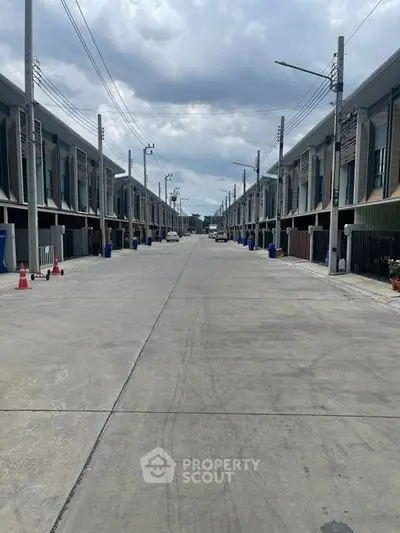 Modern townhouse complex with spacious driveway and contemporary design.