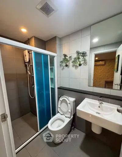 Modern bathroom with sleek shower and stylish fixtures in contemporary apartment.