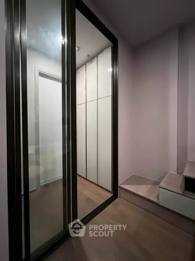 Modern interior with sleek sliding glass doors and wooden flooring, showcasing a stylish storage area.