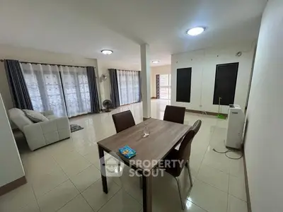 Spacious living room with modern dining area and large windows