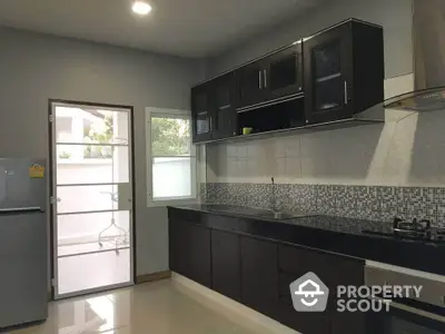 Modern kitchen with sleek black cabinets and gas stove