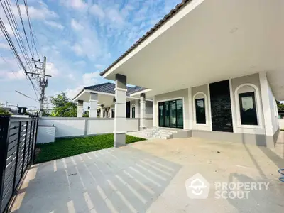 Modern single-story house with spacious driveway and lush green lawn