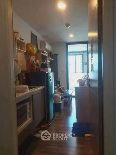 Cozy kitchen with modern appliances and open layout leading to balcony view.