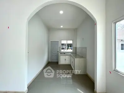 Modern minimalist kitchen with sleek tile flooring and ample natural light