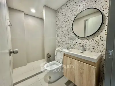 Modern bathroom with terrazzo wall and sleek fixtures
