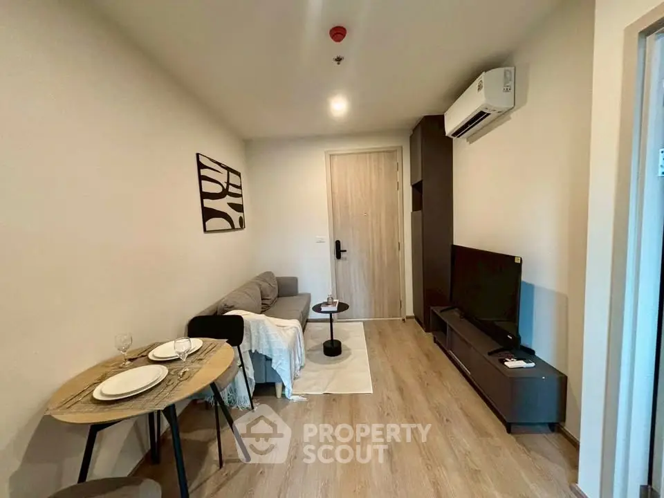 Modern living room with cozy sofa, dining table, and wall-mounted TV in stylish apartment.