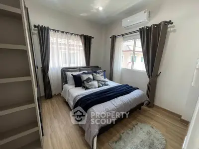 Cozy bedroom with stylish decor and natural light, featuring a comfortable bed and elegant curtains.