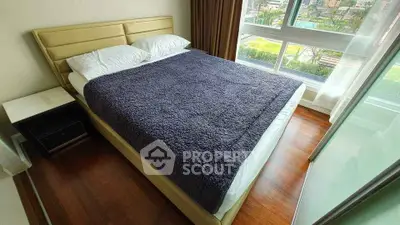 Cozy bedroom with large window and plush bedding in modern apartment