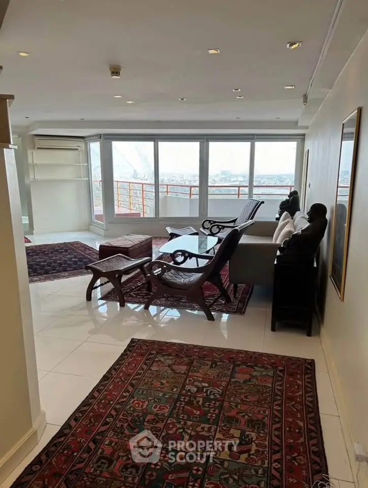 Spacious living room with large windows and elegant decor offering stunning city views.