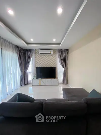 Spacious living room with modern decor and large windows for natural light.