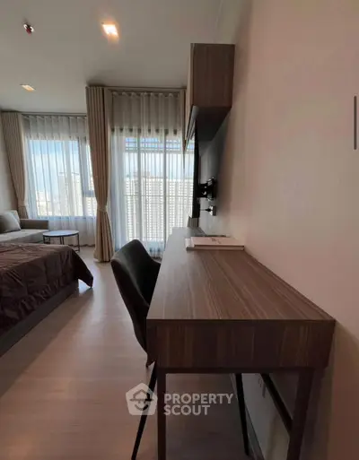 Modern bedroom with study area and large windows offering city views