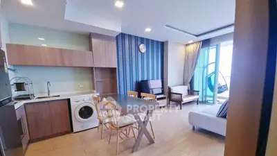 Modern open-plan living room with kitchen, featuring washing machine and stylish decor.