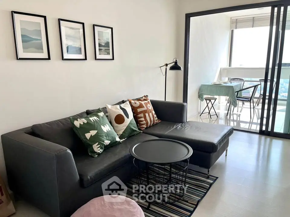 Modern living room with stylish decor and balcony view in a high-rise apartment.