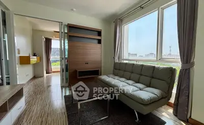 Modern living room with large windows and stylish furniture in a bright apartment.