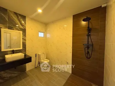 Modern bathroom with sleek design, featuring a walk-in shower and elegant fixtures.