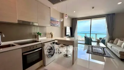 Modern open-plan kitchen and living room with stunning sea view from balcony.
