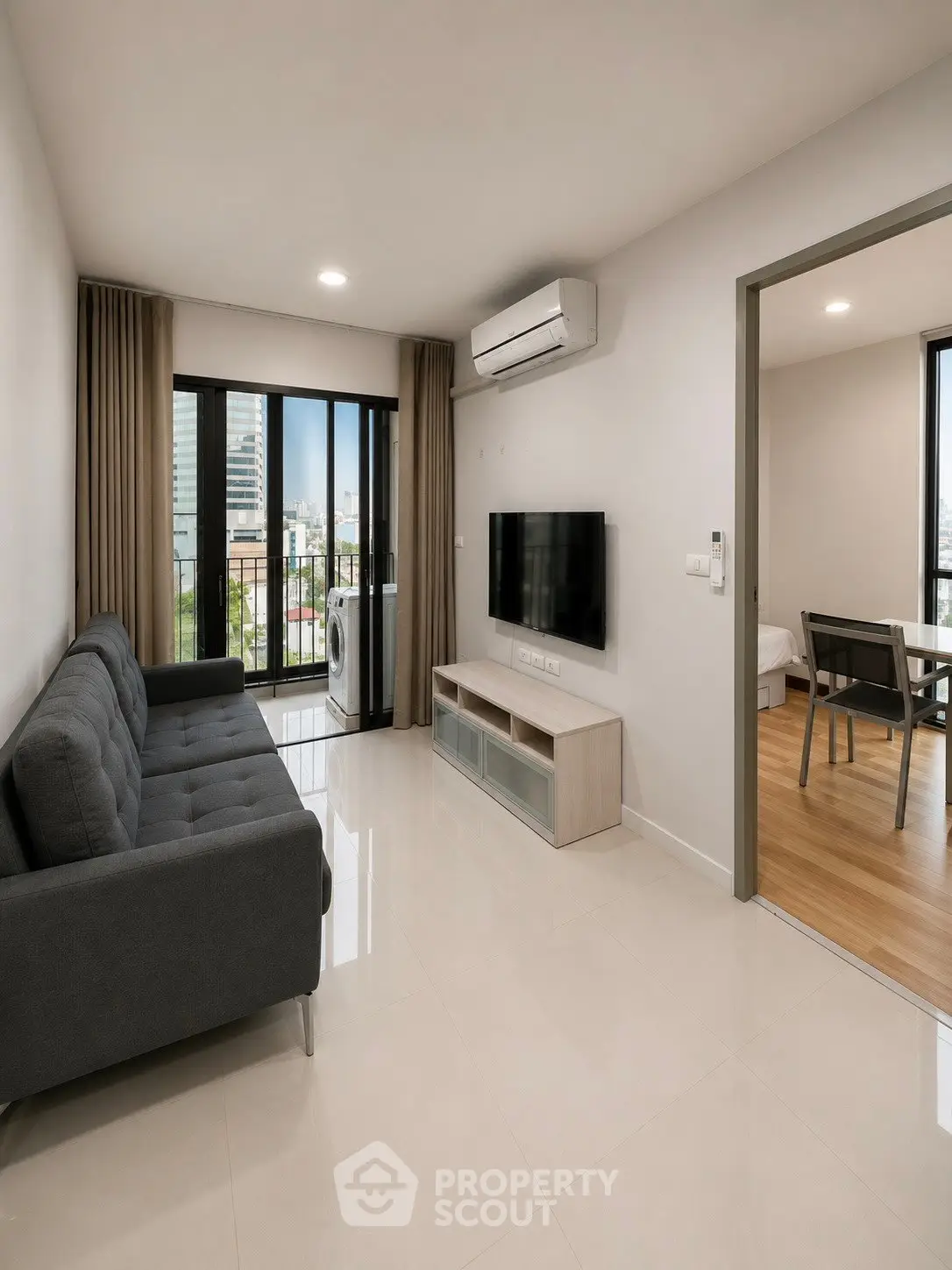 Modern living room with sleek furniture and city view balcony in a stylish apartment.