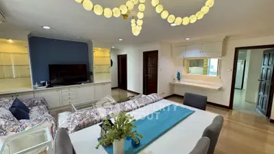 Spacious living room with elegant decor and modern lighting in a stylish apartment.