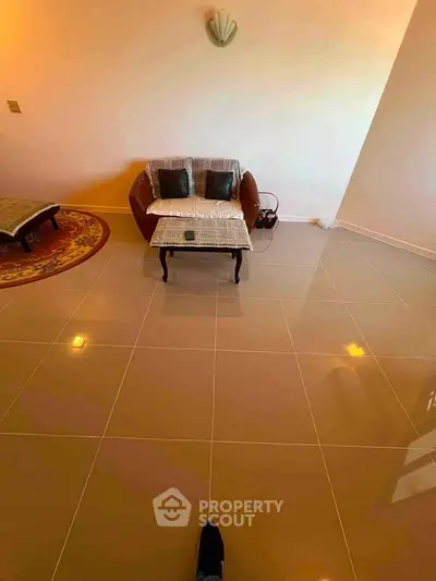 Spacious living room with elegant tiled flooring and cozy seating area.