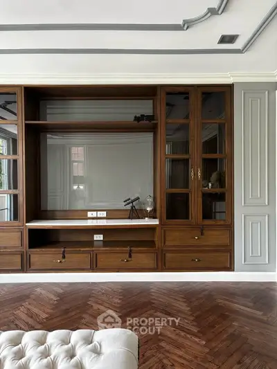 Elegant living room with built-in wooden shelves and herringbone flooring