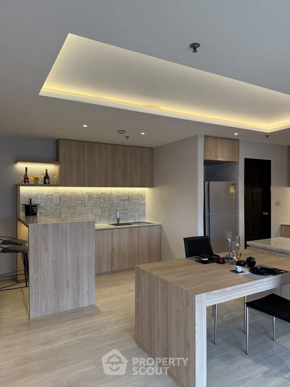Modern kitchen with sleek wooden cabinetry and ambient lighting