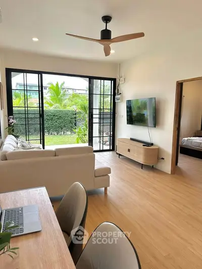 Modern living room with garden view, stylish furniture, and natural light.