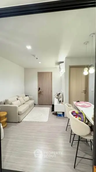 Modern living room with cozy sofa and stylish dining area in open layout.