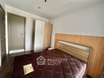 Modern bedroom with stylish wooden accents and cozy bed in a contemporary apartment.