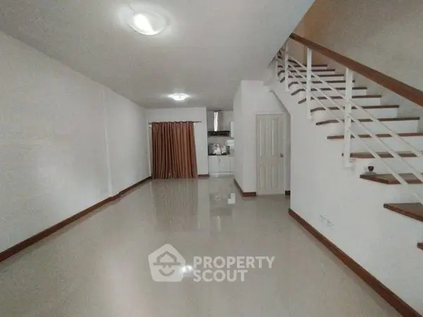 Spacious open-plan living area with modern staircase and sleek flooring