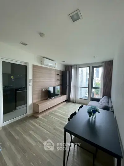 Modern living room with sleek furniture and large windows offering natural light.