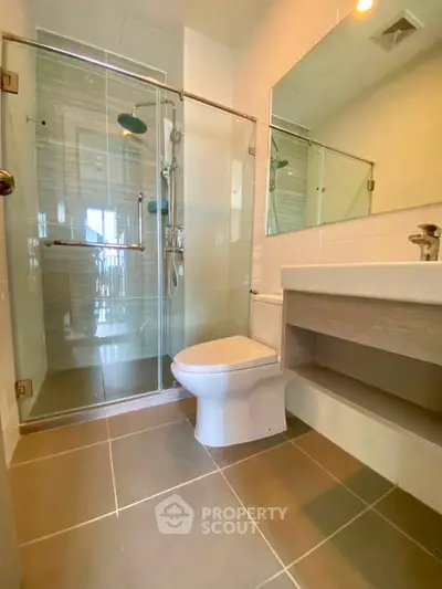 Modern bathroom with glass shower and sleek fixtures in a contemporary apartment.