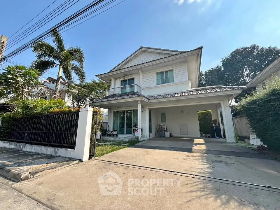 Charming two-story house with spacious driveway and lush greenery in a serene neighborhood.