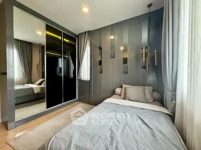 Modern bedroom with sleek design, mirrored wardrobe, and cozy bedding in a stylish apartment.