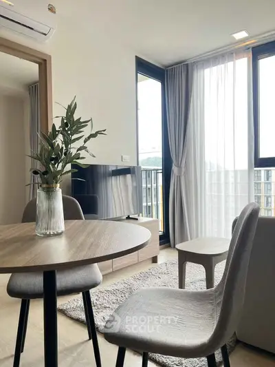 Modern living room with stylish furniture and large windows offering natural light and a cozy atmosphere.