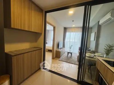 Modern apartment interior with open living room and dining area, featuring sleek wooden finishes and natural light.