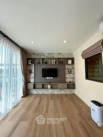 Modern living room with elegant built-in shelving and large window for natural light.