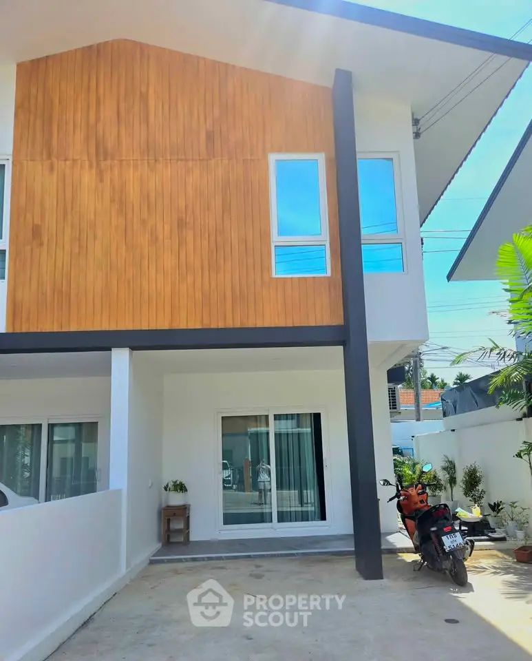 Modern two-story house with wooden facade and spacious driveway