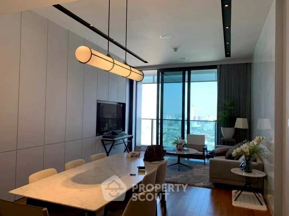 Modern living room with city view, elegant lighting, and stylish furniture in a high-rise apartment.