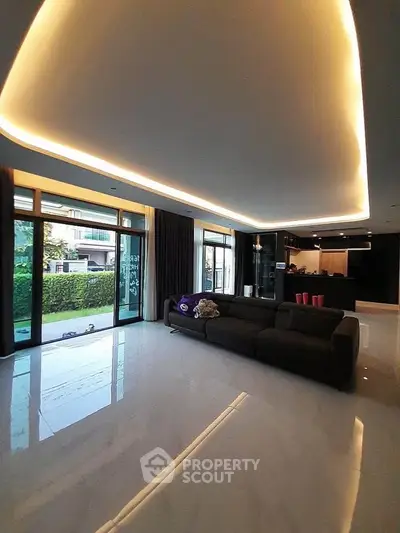 Spacious modern living room with elegant lighting and garden view, perfect for luxury living.