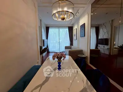 Elegant living room with marble dining table and modern chandelier, featuring a cozy seating area and large windows.