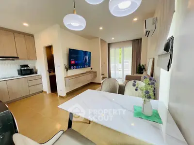 Modern living room with open kitchen, stylish decor, and natural light