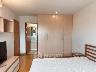 Spacious bedroom with modern wardrobe and ensuite bathroom in a stylish apartment.