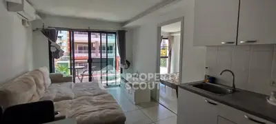 Modern living room with open kitchen and balcony view in a stylish apartment.