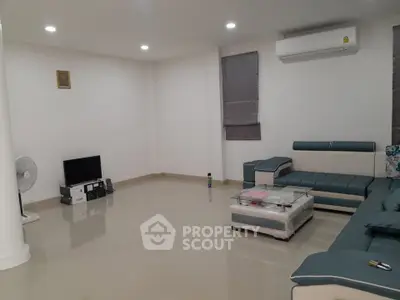 Spacious modern living room with sleek furniture and air conditioning, perfect for relaxation and entertainment.