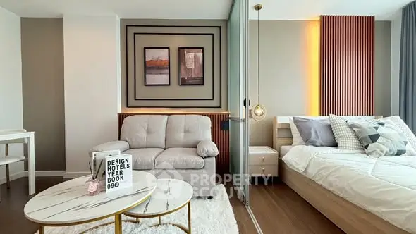 Modern bedroom with stylish decor and cozy seating area in luxury apartment.