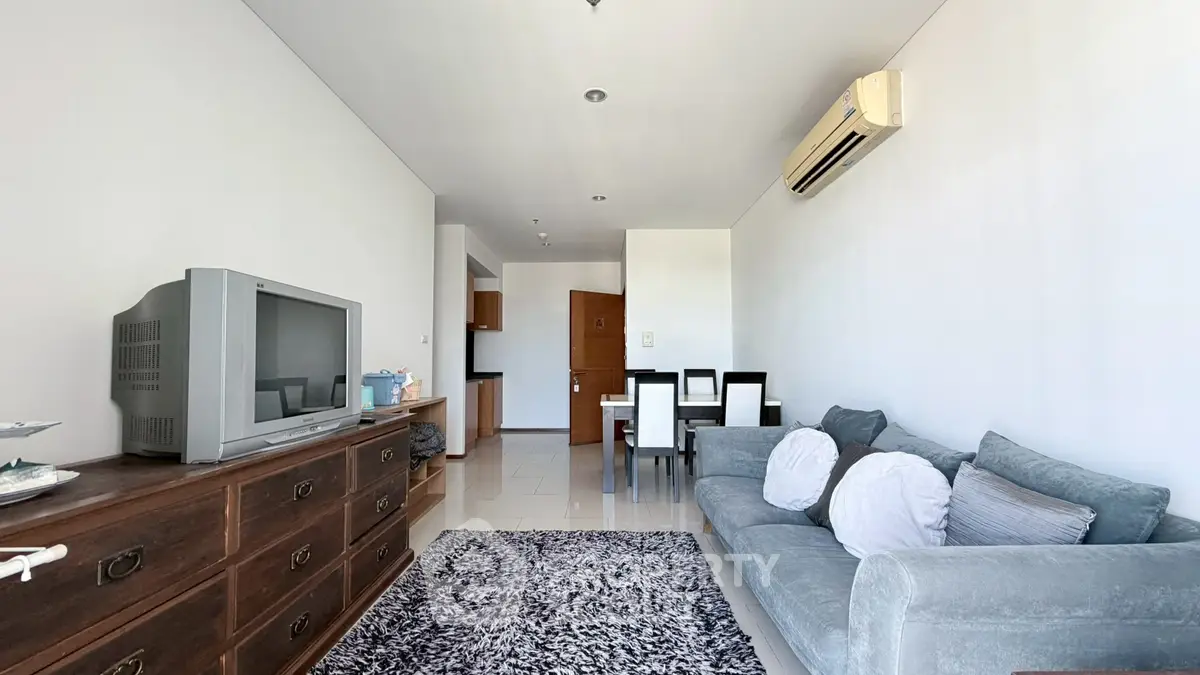 Spacious living room with modern decor and air conditioning in a stylish apartment.