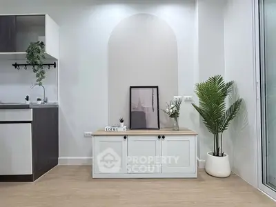 Modern minimalist living room with stylish decor and sleek kitchen area