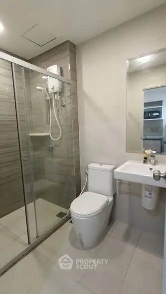 Modern bathroom with glass shower enclosure and sleek fixtures.