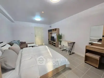 Spacious modern bedroom with cozy bed, stylish furniture, and ample natural light.