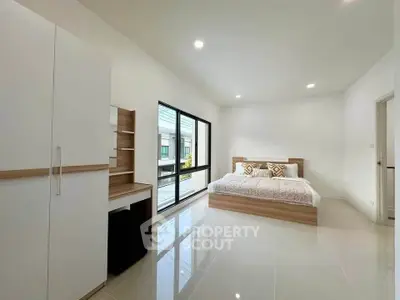 Spacious modern bedroom with large windows and sleek furniture